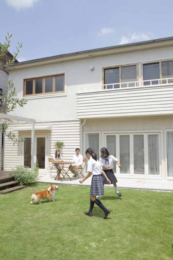 庭で家族と犬が遊んでいる